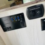 RV rental interior showing a control panel with switches & indicators for tanks/battery, and a charging center with USB/12V ports. — photo 12