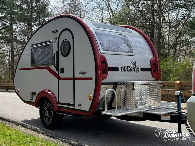 A white and red nuCamp T@B 320 teardrop trailer, ready for your next rv rental adventure. Compact and stylish for travel.