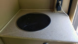 RV rental kitchenette: A compact counter with a built-in cooktop and electrical outlet for convenient mobile living.