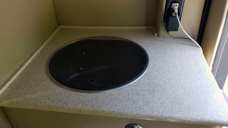 RV rental kitchenette: A compact counter with a built-in cooktop and electrical outlet for convenient mobile living.