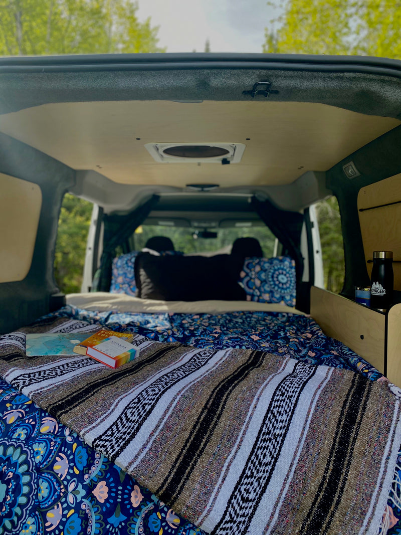 Cozy camper van interior, a perfect RV rental setup with bed, books, and views of nature. — photo 3