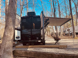 Enjoying the outdoors in an RV rental! This camper van is set up for a cozy stay at a sunny campground.