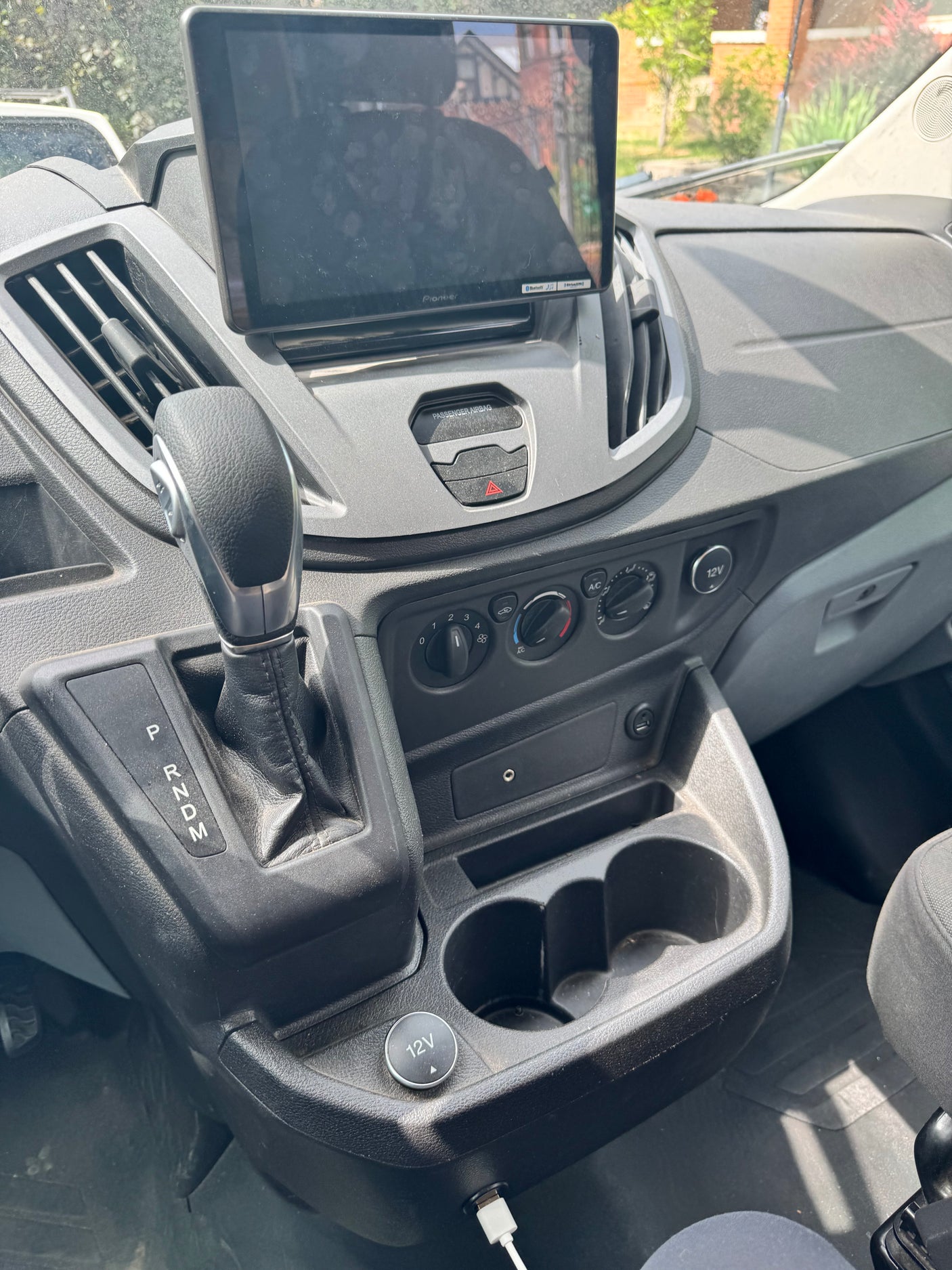Inside an RV rental: dashboard view with gear shifter, Pioneer screen, climate controls, and charging ports.