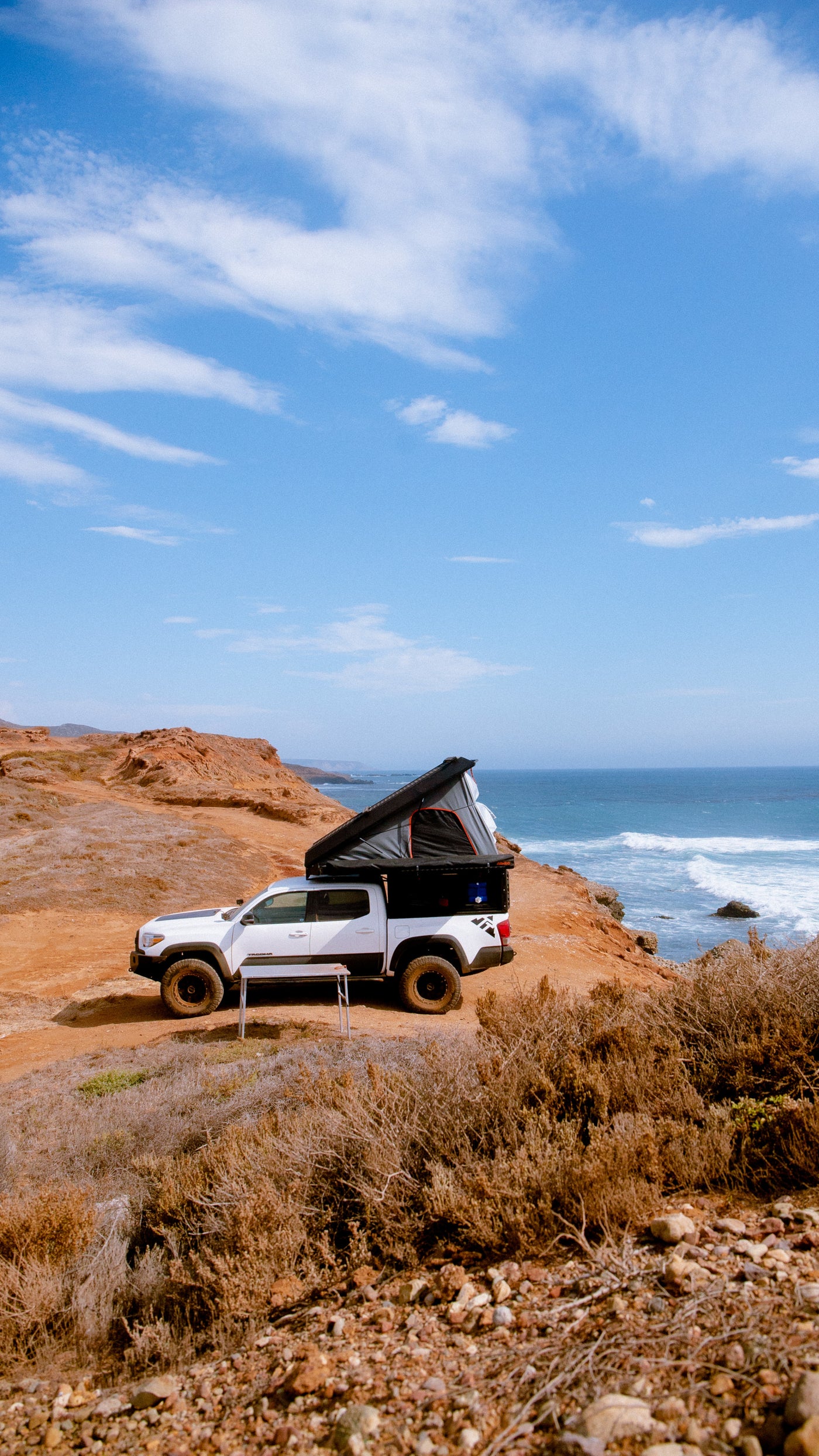 Coastal camping: White pickup truck with deployed pop-up camper on a cliff overlooking the ocean. RV rental ready! — photo 2