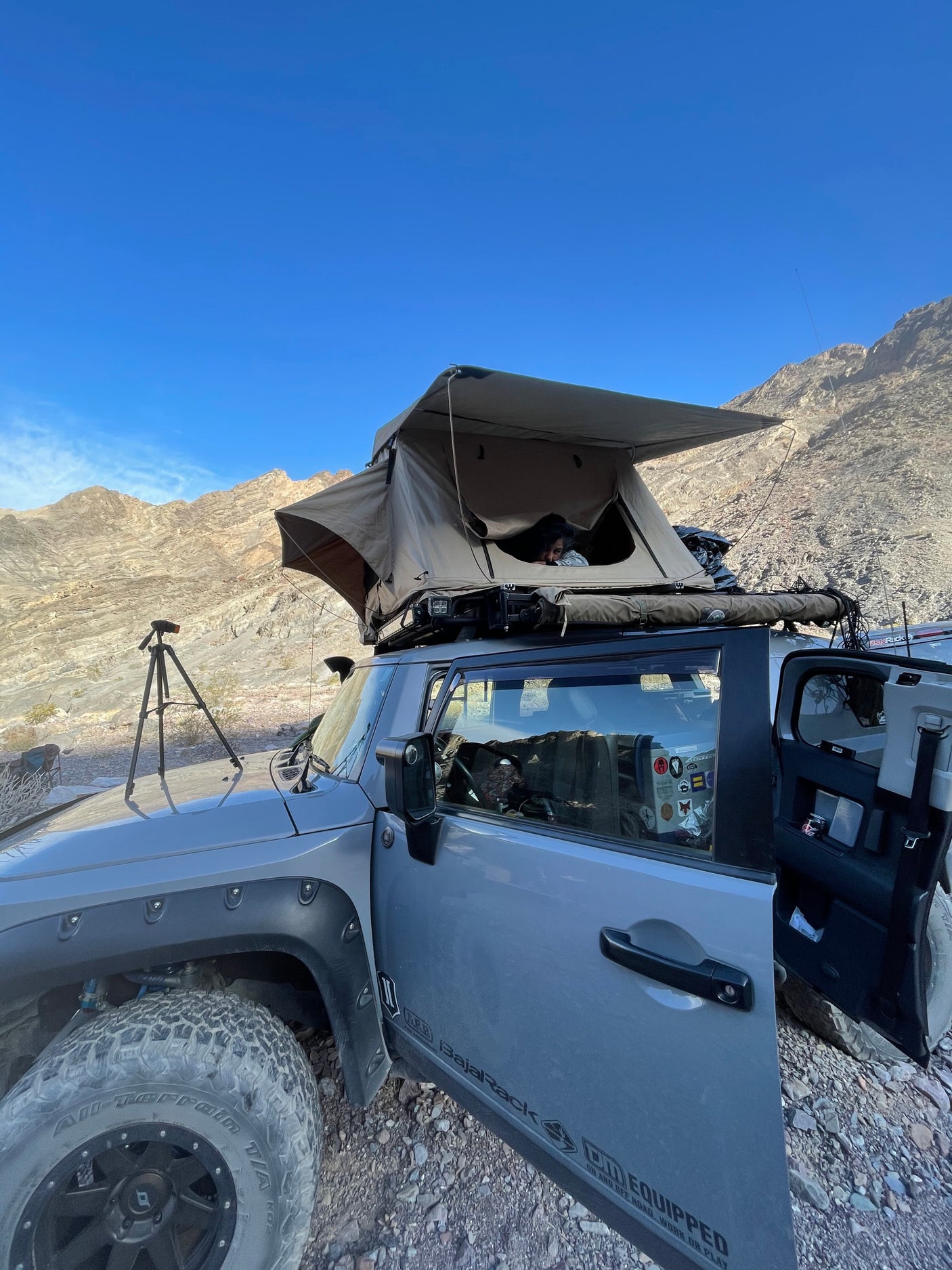 Adventure-ready off-road vehicle with rooftop tent in a rocky mountain landscape, ideal for an RV rental outdoor experience.