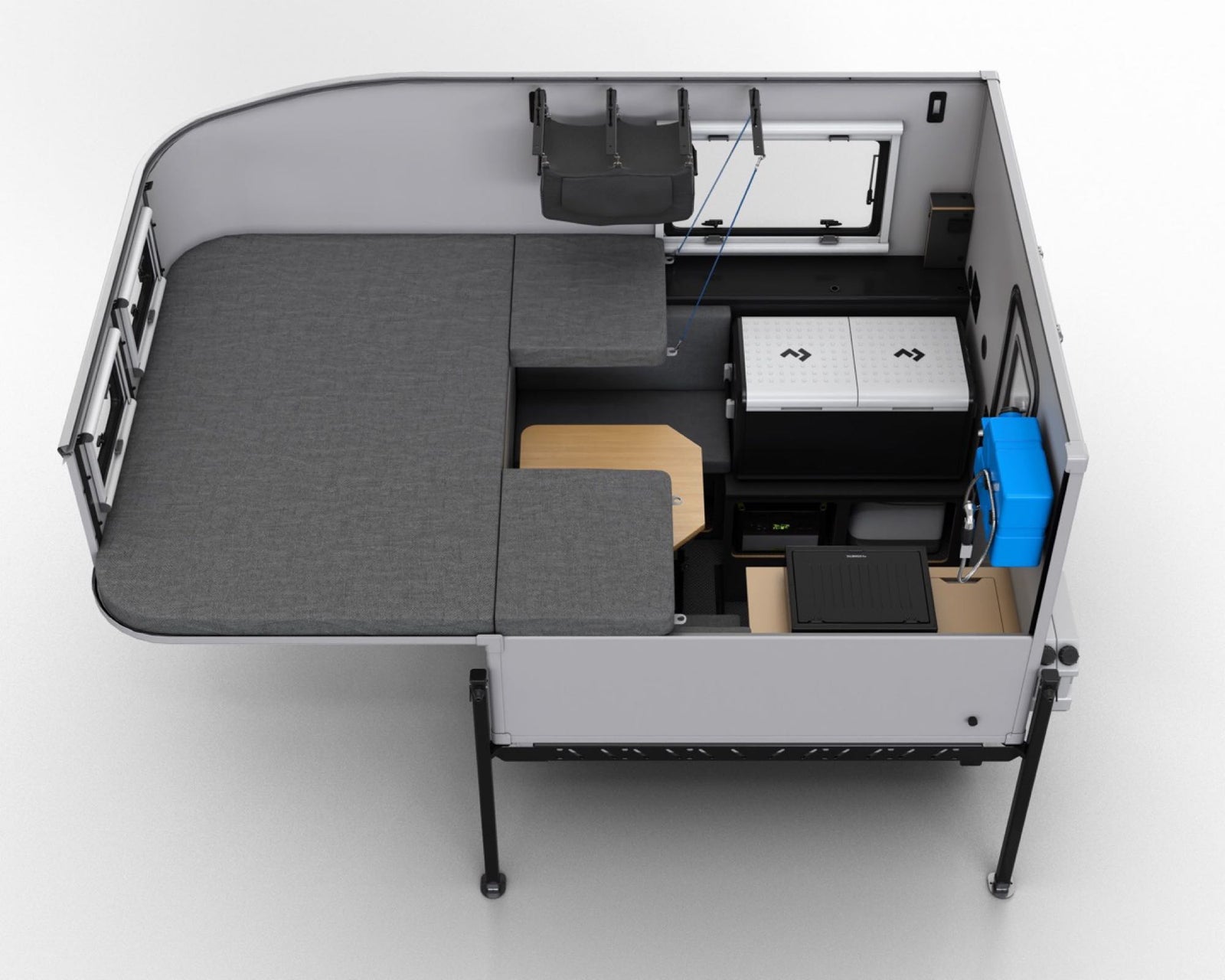 Aerial view of a modern RV rental interior, featuring modular bed/seating, a portable fridge, and a functional table.