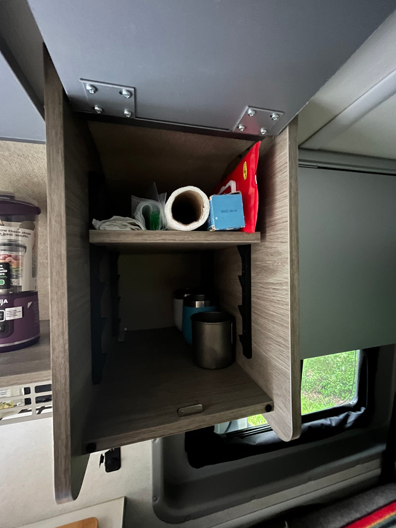 Overhead cabinet storage inside an RV rental, showing organized shelves with kitchen supplies and travel mugs. — photo 13
