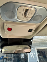 RV rental interior: Overhead console with dome lights, SOS, ASSIST buttons, and light controls above the rearview mirror.