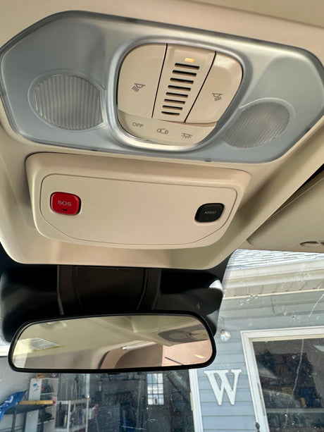 RV rental interior: Overhead console with dome lights, SOS, ASSIST buttons, and light controls above the rearview mirror.