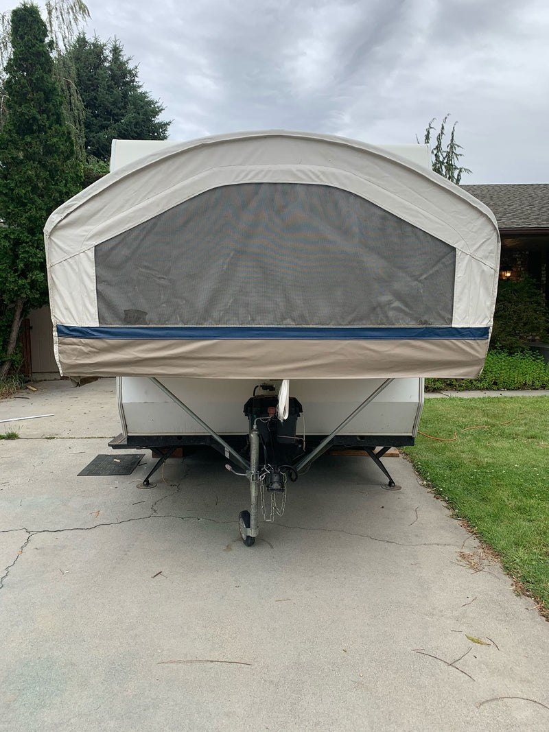 Front of a tan pop-up camper RV rental with a mesh window, parked on a driveway, ready for adventure. — photo 3