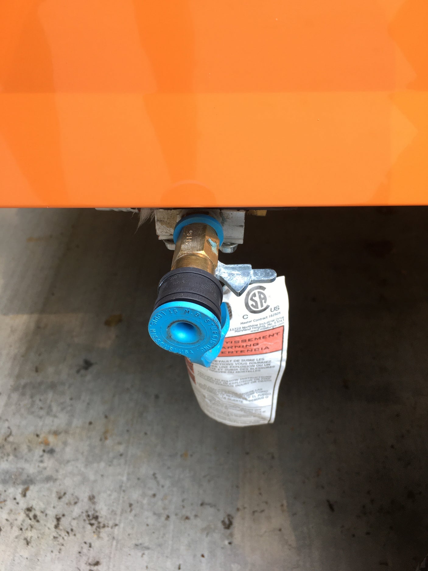 An RV rental features a blue quick-connect propane fitting and shut-off valve, ready for external gas hookups.