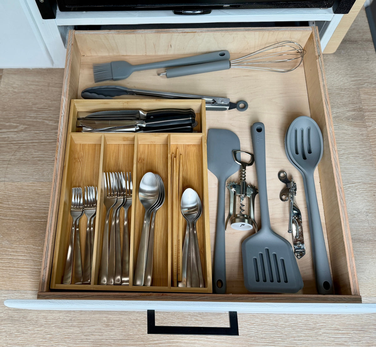 Organized kitchen drawer in an RV rental, featuring neatly arranged utensils, cutlery, and cooking tools for your trip. — photo 11