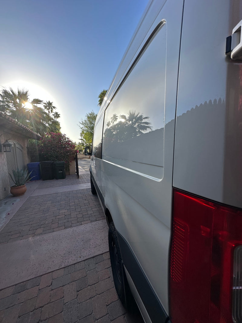White RV rental van reflecting palm trees on a sunny brick driveway, ready for adventure. — photo 8