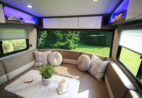 Cozy RV rental interior with a spacious U-shaped dinette, stylish decor, and panoramic views. Perfect for travel comfort.