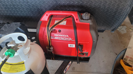 RV rental setup: Honda EU2000i generator and propane tank secured for travel, ready for adventure and off-grid power.