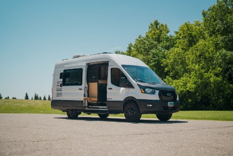 White Ford Transit van RV rental, side door open, showcasing its spacious campervan interior. Ready for adventure!