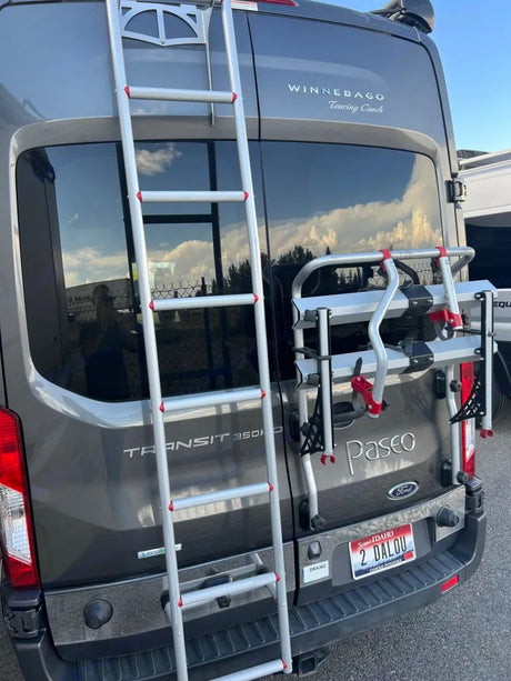 RV rental: Back of a grey Winnebago van with ladder, bike rack, and Idaho plate, ready for adventure.