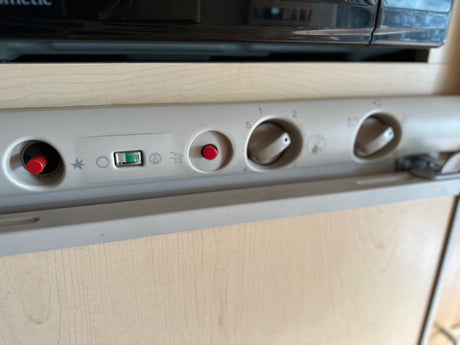 RV rental Dometic fridge/freezer controls: temperature knobs, igniter buttons, and a power indicator for guests.