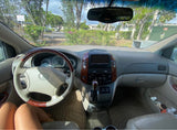 Minivan interior, common sight for RV rental adventurers: driver's view of dash, steering wheel, and outside park.