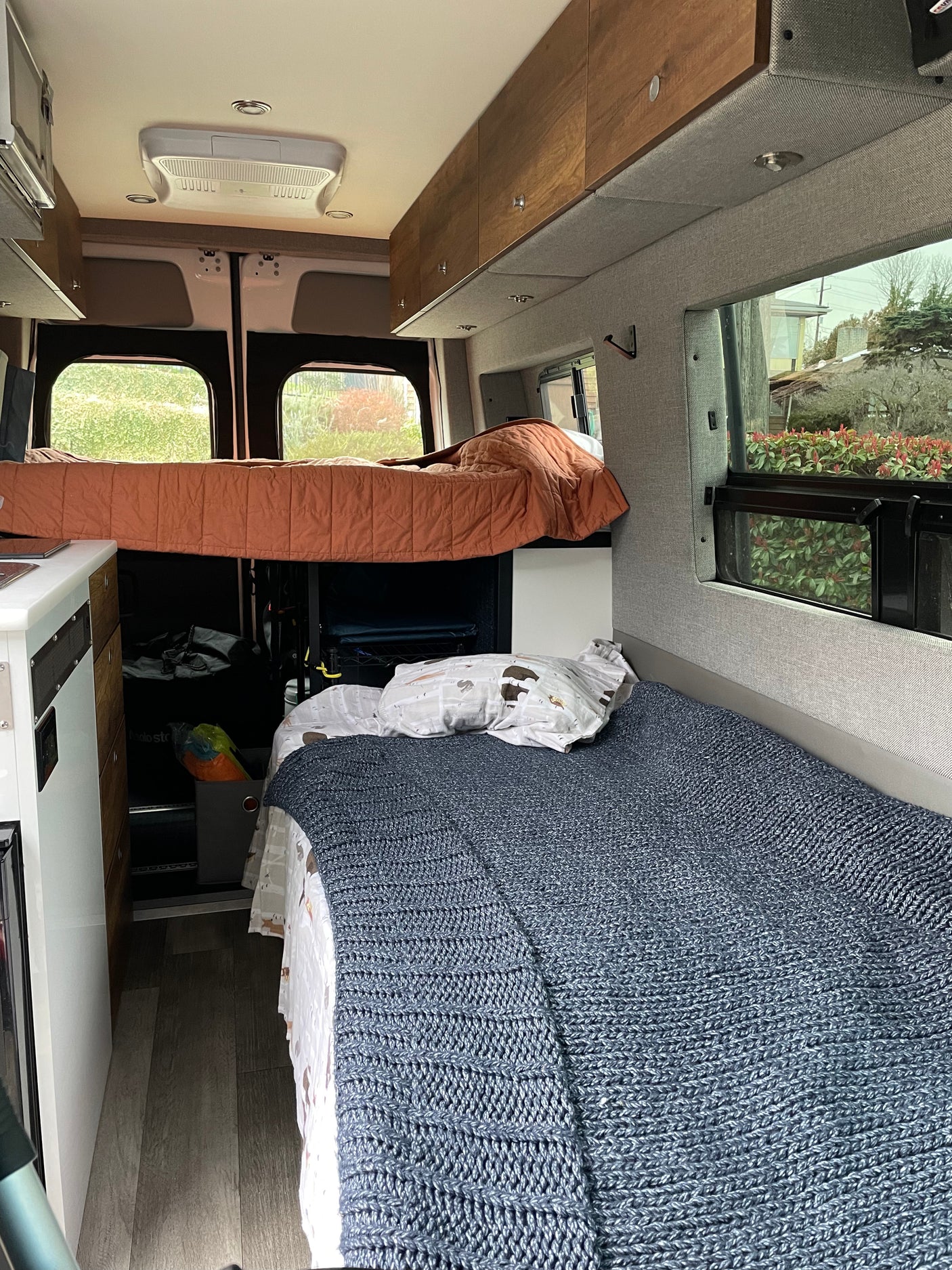 Spacious RV rental interior with bunk and lower beds, overhead storage, and large windows for travel comfort.