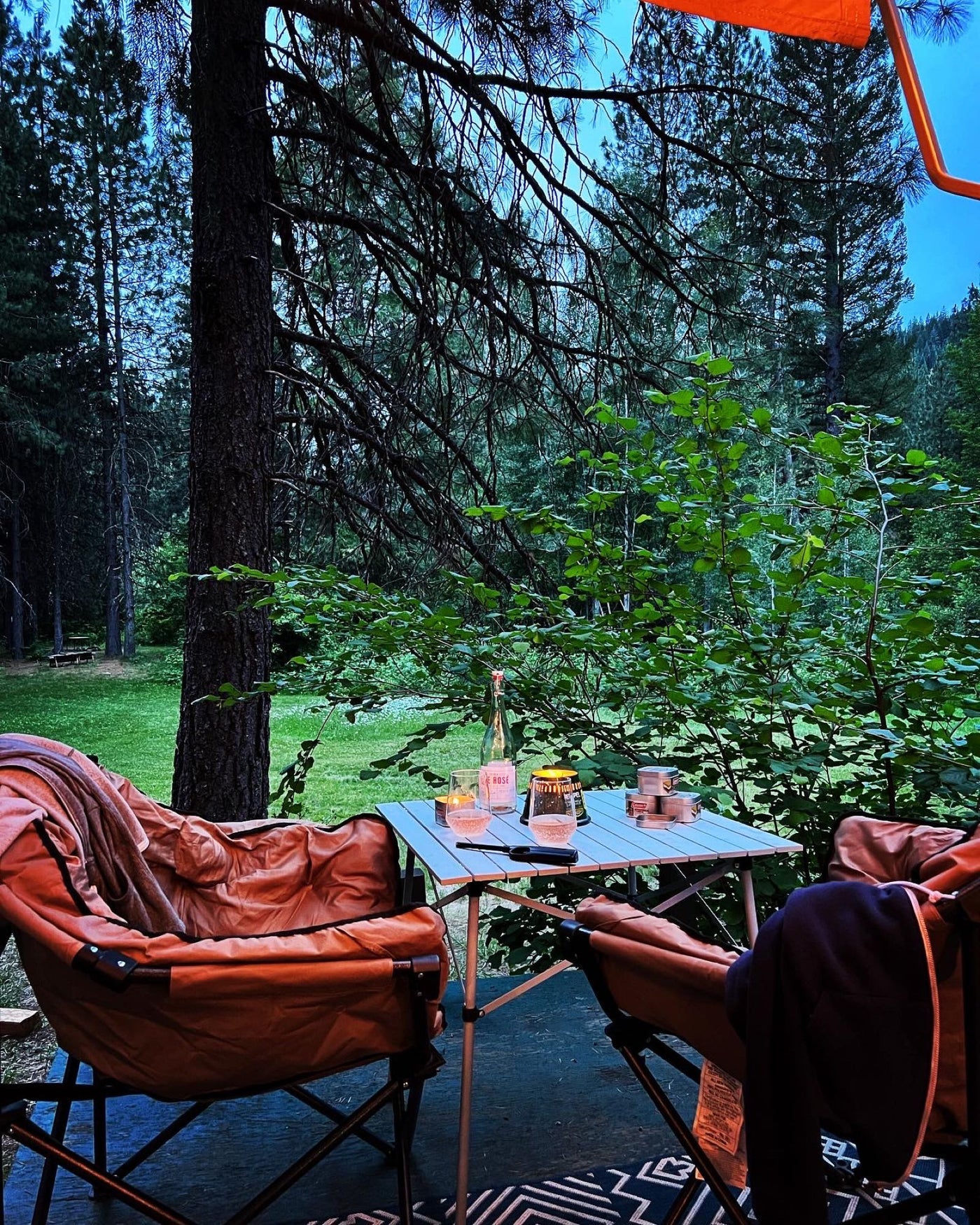  and a cooler.|A silver Airstream RV rental brightly lit by string lights at dusk — photo 8