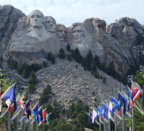 Iconic Mount Rushmore, showcasing carved presidents and state flags, ideal for an RV rental adventure.