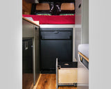 RV rental camper van interior: red bed, Tetravan fridge, metallic cooler, and open pull-out drawer for efficient space.