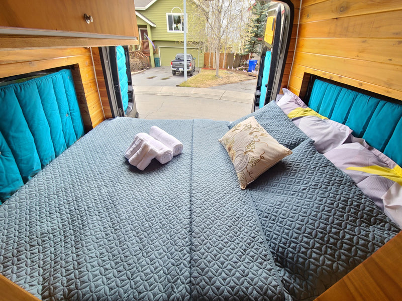  and a cozy bed for your next adventure.|Comfortable RV rental bedroom: blue quilted bed — photo 3
