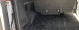 RV rental interior: Rear cargo area with a dark carpeted floor, a bench seat with buckles, and side wall paneling.