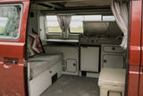 RV rental: Inside a classic Westfalia camper van, showing kitchen, sleeping area, and a Yeti cooler.