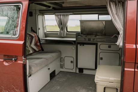RV rental: Inside a classic Westfalia camper van, showing kitchen, sleeping area, and a Yeti cooler.