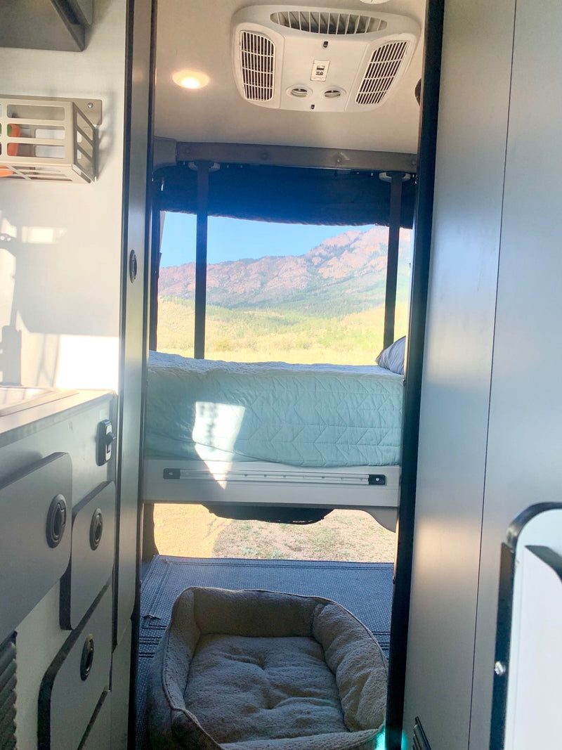  cloudy sky.|Serene desert mountain view from inside an RV rental. A cozy kitchen setup with coffee — photo 4