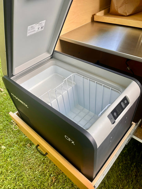  perfect for outdoor cooking in a rainy forest.|Compact galley kitchen in a teardrop RV rental with Dometic fridge