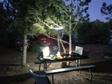 Night camp setup: bright lantern illuminates picnic table, food & car. Get ready for an RV rental adventure.