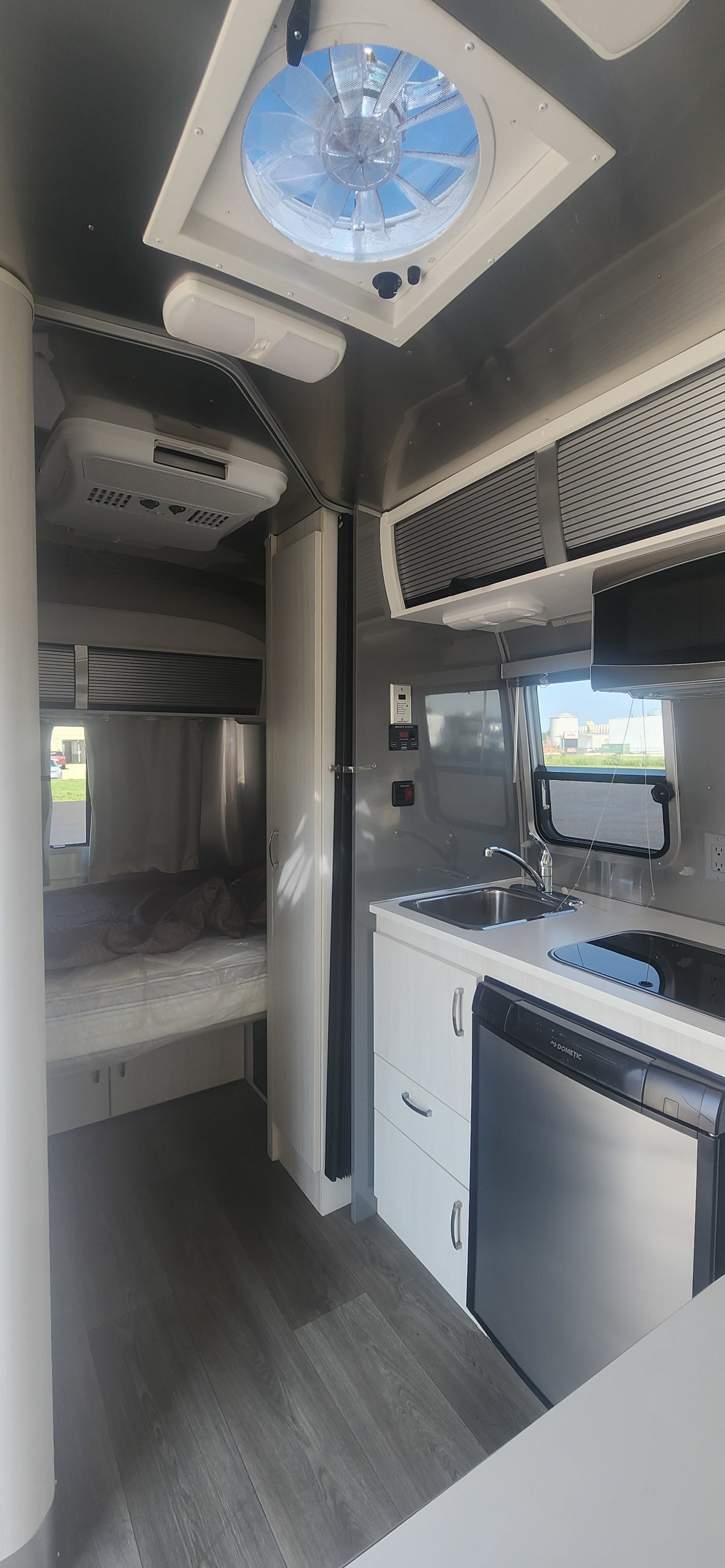 Modern RV rental interior with full kitchen, bedroom, and essential amenities for comfortable travel.