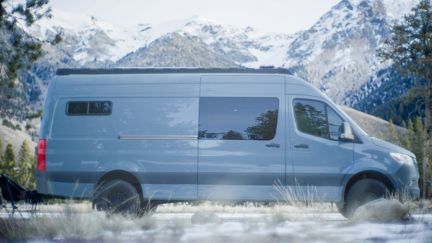 Adventure-ready RV rental camper van parked in snowy mountains. Ideal for winter outdoor exploration.