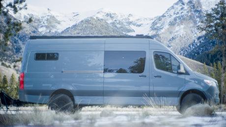 Adventure-ready RV rental camper van parked in snowy mountains. Ideal for winter outdoor exploration.