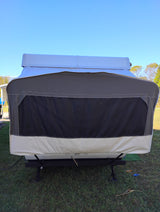 Front view of a pop-up camper RV rental, fully set up on grass under a clear sky, ready for your next camping trip.