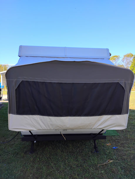 Front view of a pop-up camper RV rental, fully set up on grass under a clear sky, ready for your next camping trip.