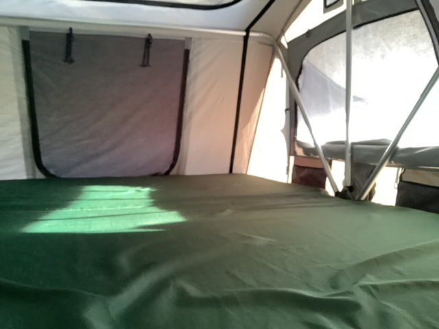  ready for adventure camping. A versatile RV rental!|Interior of an RV rental sleeping space. Features a green mattress — photo 3