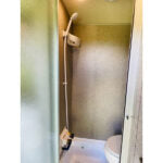 This RV rental's compact, all-in-one bathroom includes a stand-up shower and toilet, ideal for travel comfort. — photo 9