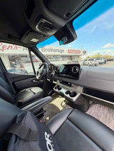 Modern RV rental van interior: Sleek dashboard, black leather seats. Parked outside a vehicle brokerage offering financing.