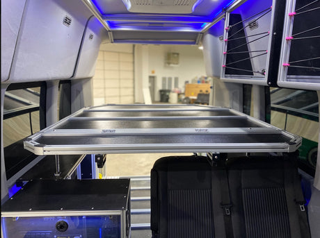  and a pull-out cargo platform with bins.|White camper van with an extended awning & open doors