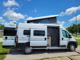 Bright white Winnebago Solis pop-top camper van with doors open, ready for your next RV rental adventure.