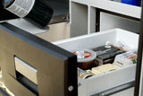 An RV rental's pull-out fridge, part of an outdoor kitchen, holds food like brats & organic eggs for camping meals.
