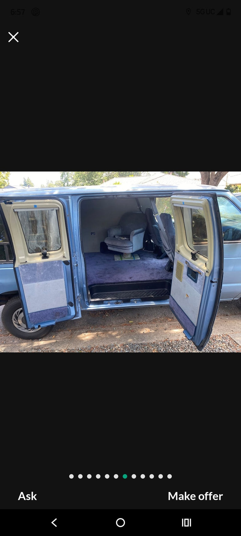 Light blue conversion van's spacious interior for RV rental. Features plush blue carpet & swivel armchair with side doors open. — photo 8