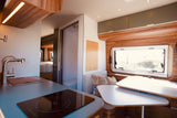 Inside a bright **rv rental**: modern kitchen, dining, bathroom, and rear bedroom. A complete home on wheels for adventure.