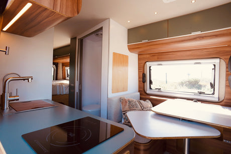 Inside a bright **rv rental**: modern kitchen, dining, bathroom, and rear bedroom. A complete home on wheels for adventure.