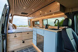 Experience coastal living in this stunning RV rental van, featuring a bed & full kitchen with ocean views.