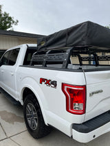 White Ford F-150 FX4 off-road truck with RCI bed rack and rooftop tent, perfect for camping or an RV rental adventure.